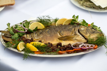 carp  with lemon, dill and raisins on plate