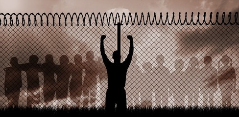 Composite image of silhouette athlete with hands raised 
