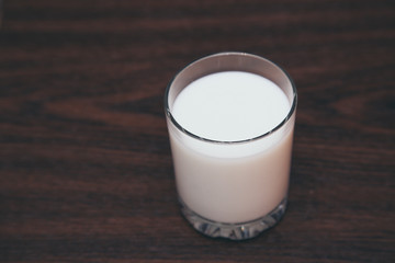 glass of milk on wooden background