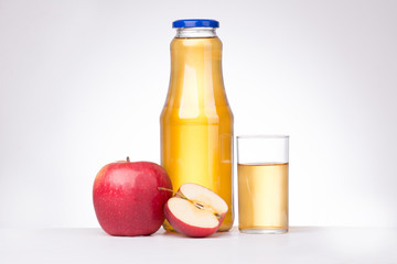 Apples with bottle of juice and glass on white background