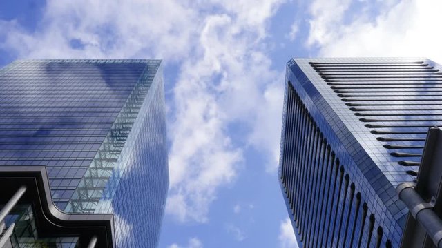 Time-lapse of cloud moving between corporate buildings.
