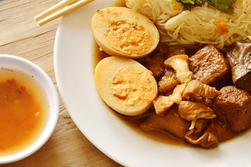 thin rice noodle with pork entrails and tofu topping egg on plate