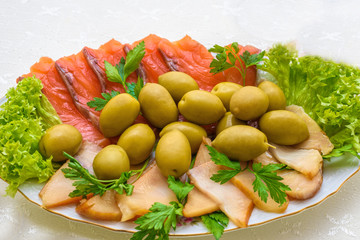 Smoked salmon and fish with olives appetizer. Russian cuisine