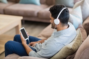 Man listening to music on mobile phone in living room