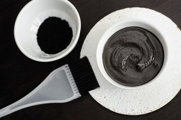 DIY charcoal face mask in a small ceramic bowl. Homemade cosmetics