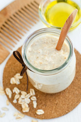 Homemade oatmeal mask in a glass jar and wooden hair comb. Gentle scrub for sensitive skin