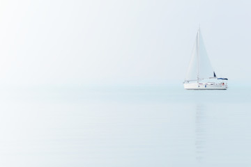 Zeilboot op blauwe zee met mistig weer. Zeilschip op het Balatonmeer.