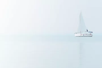 Afwasbaar Fotobehang Zeilen Zeilboot op blauwe zee met mistig weer. Zeilschip op het Balatonmeer.