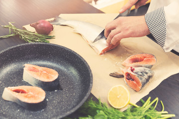 seafood - chef slicing salmon fish for preparing