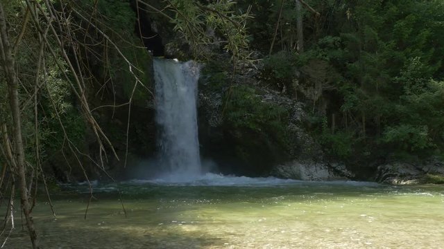 SLOW MOTION: Man paddling his kayak through raging whitewater waterfall