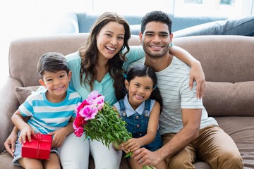 Portrait of parents and kids sitting on sofa 