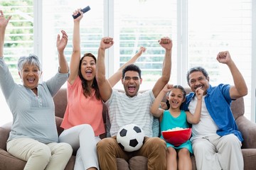 Happy family watching soccer match on television