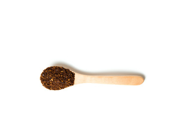 A chili flakes in a wooden spoon isolated over white background