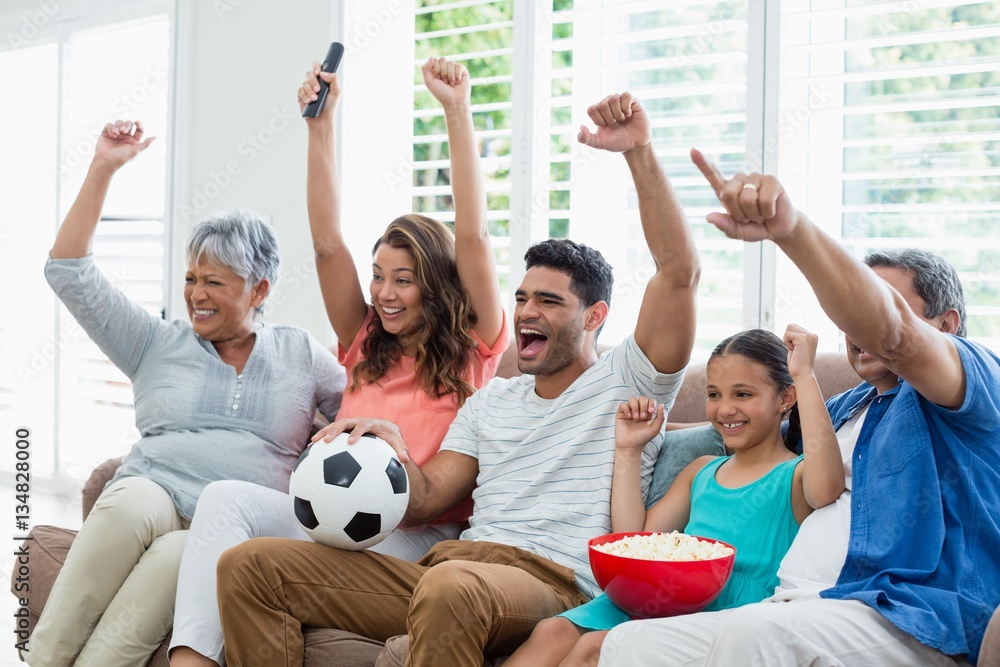 Poster Happy family watching soccer match on television