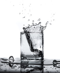 water splash with ice in glass isolated on white background