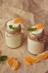 Organic yougurt with fresh tangerine and mint in glass jars
