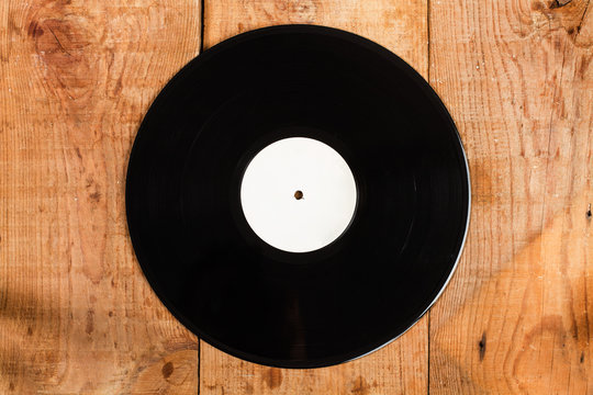 Disco LP Vinilo sobre un fondo de madera rústico. Vista superior