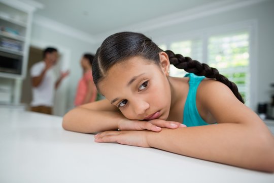 Sad girl listening to her parents arguing - Powered by Adobe