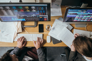 From above photo of businessman typing on his office computer.