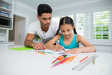 Father assisting her daughter in doing her homework