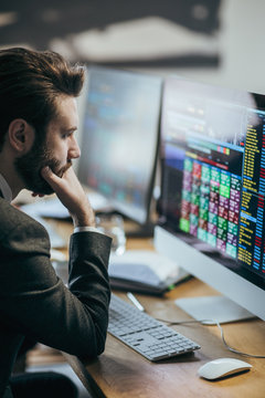 Broker analysing stock market on his computer.