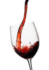 Red wine poured in a glass isolated on white