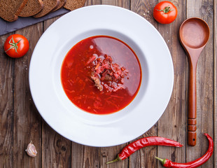 Beet soup in white plate with vegetables