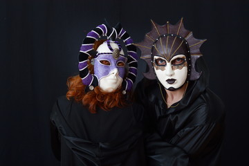 girl in red hair and a guy in an old Venetian masks