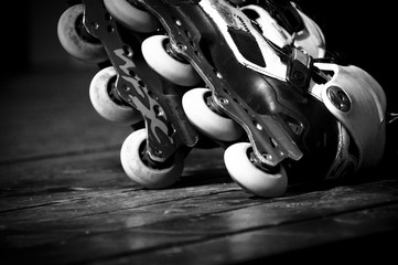 Rollerblades on wooden floor in black an white