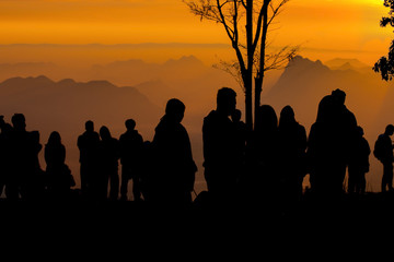 Fototapeta na wymiar silhouette of people the cliff and looking at the valley and mountains with sunrise in the morning