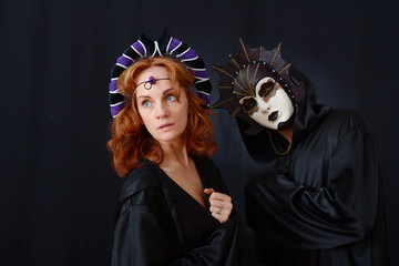 girl in red hair and a guy in an old Venetian masks
