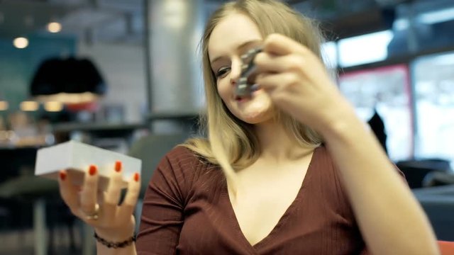 Girl sitting in the cafe and looking on her new wristwatch 
