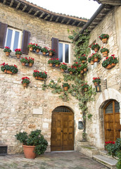 Fototapeta na wymiar Medieval corner with flower and pots in a small town in Italy.