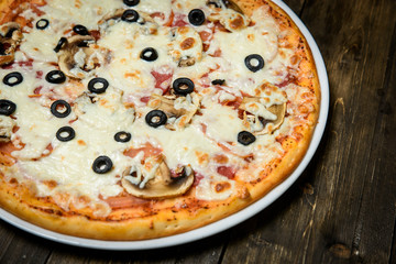 Top view of Italian rustic PIZZA on wooden table background