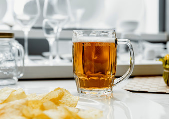 Beer and chips on the large white table