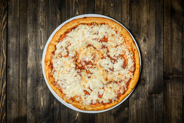 Top view of Italian rustic PIZZA on wooden table background