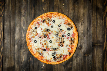 Top view of Italian rustic PIZZA on wooden table background