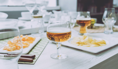 Beer and chips on the large white table