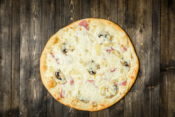 Top view of Italian rustic PIZZA on wooden table background