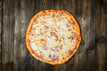 Top view of Italian rustic PIZZA on wooden table background