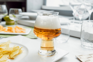 Beer and chips on the large white table