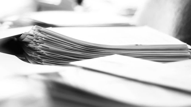 Close up of paper stacks, unsolved paper documents in the office. Shallow DOF. Suitable for backgrounds.