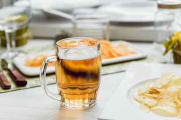 Beer and chips on the large white table