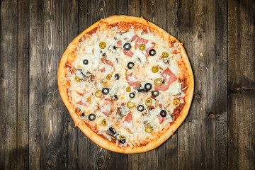 Top view of Italian rustic PIZZA on wooden table background