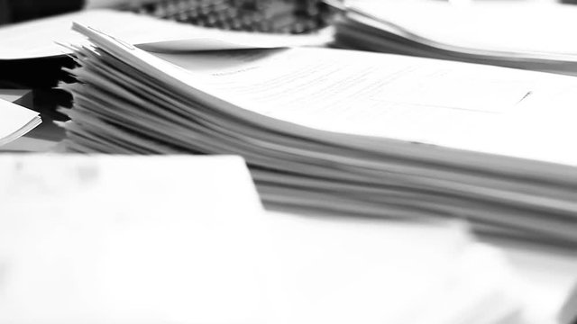 Close up of paper stacks, unsolved paper documents in the office. Shallow DOF. Suitable for backgrounds.