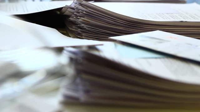 Close up of paper stacks, unsolved paper documents in the office. Shallow DOF. Suitable for backgrounds.