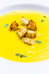 Butternut Squash Soup Detail with Fried Bread Pieces on White Plate