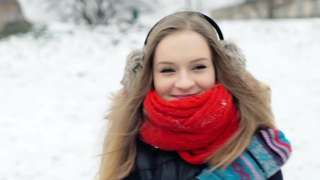 Pretty girl standing in the park at winter time and warming herself, steadycam shot
