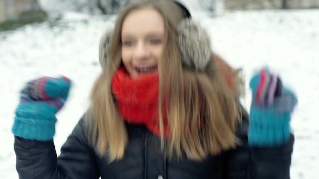 Happy girl jumping in the park and warming herself at wintry day, steadycam shot
