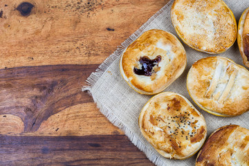 Meat and vegetable pies on the wooden table